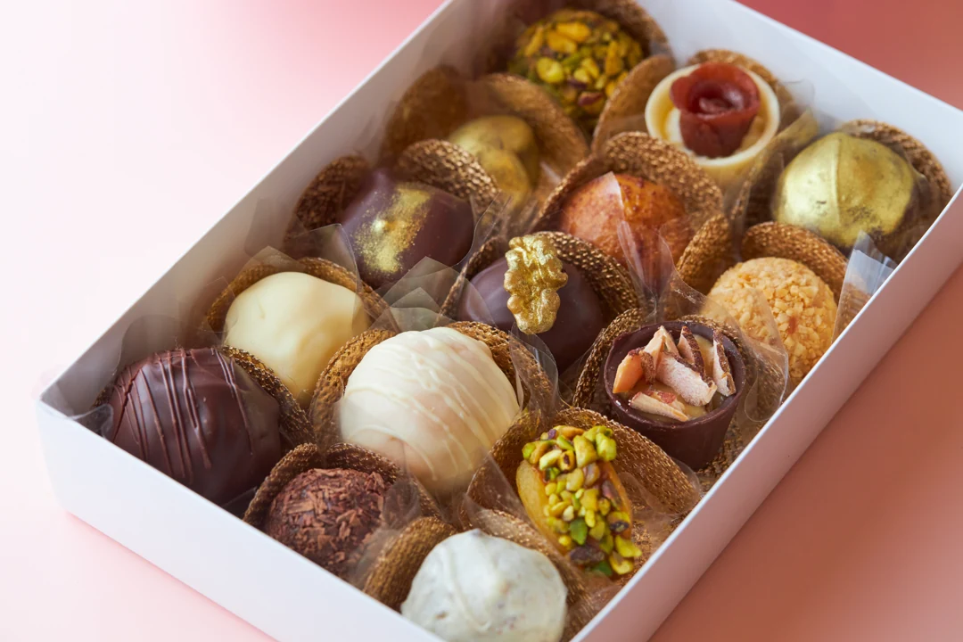 Caixa aberta com brigadeiros, bombons e doces variados da Healthy Bites
