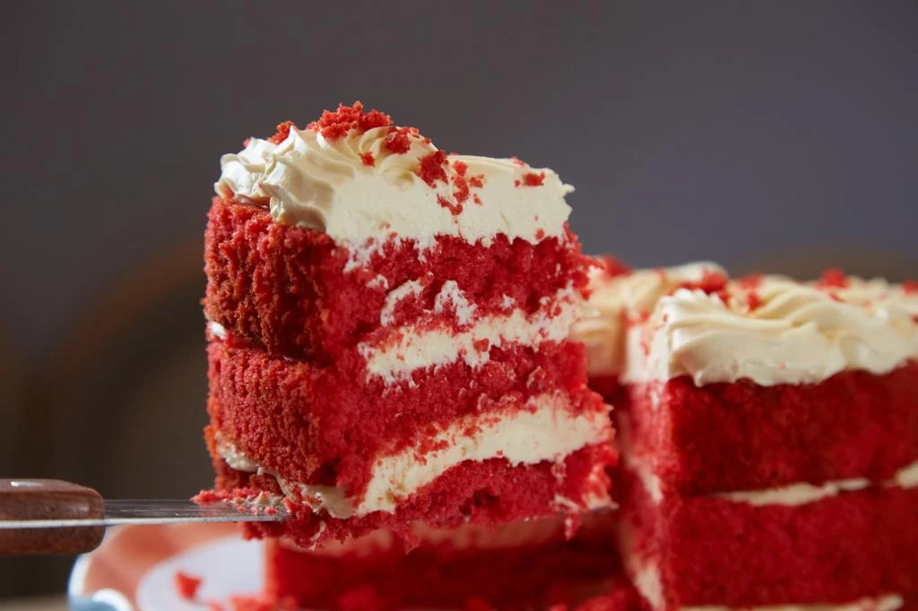 Red Velvet em corte com camadas vermelhas e cobertura clara